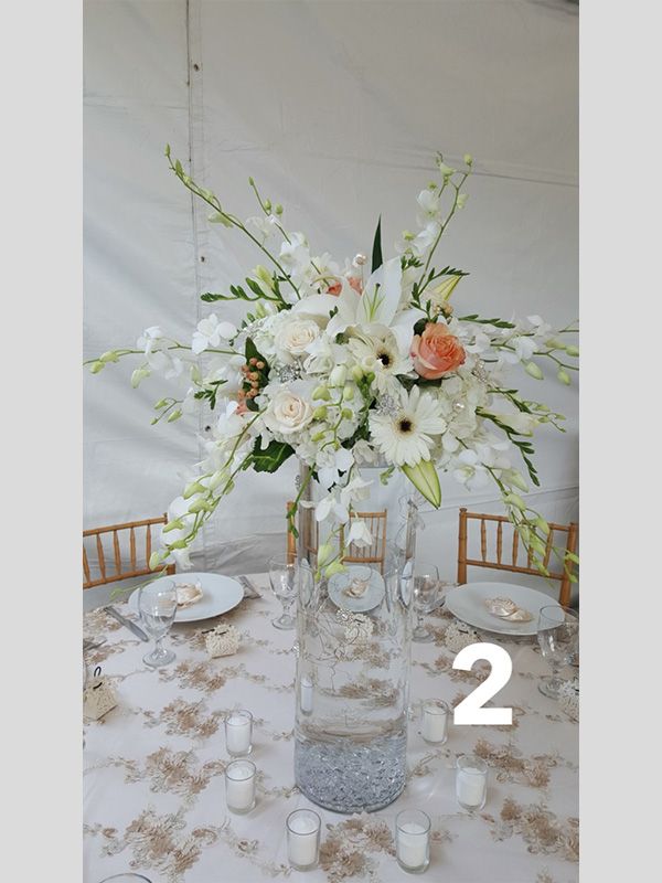 A table with a vase of flowers and candles on it.