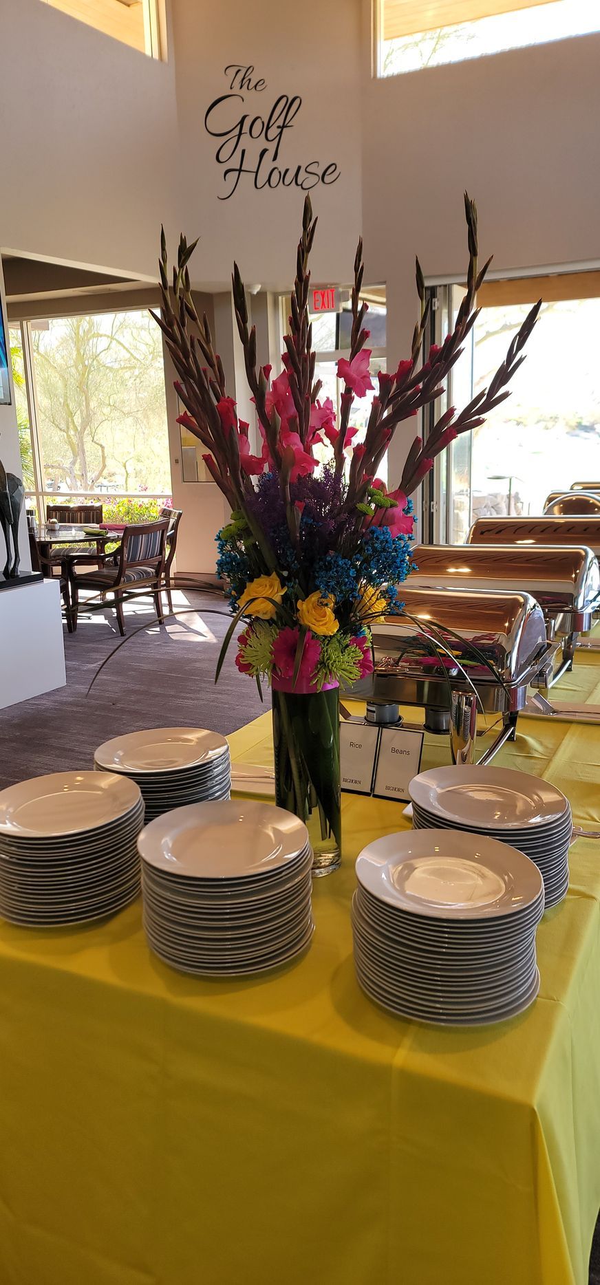 A table with plates and a vase of flowers on it.