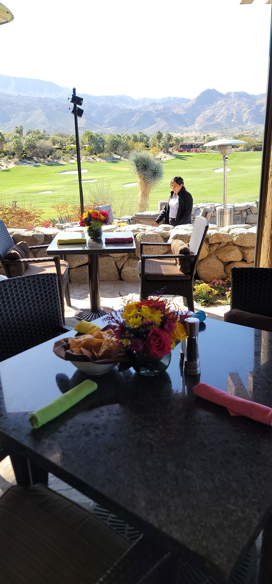 A table with flowers on it and a view of a golf course.