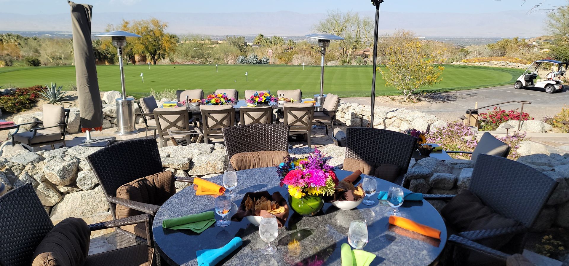 A table with flowers on it and a golf cart in the background.