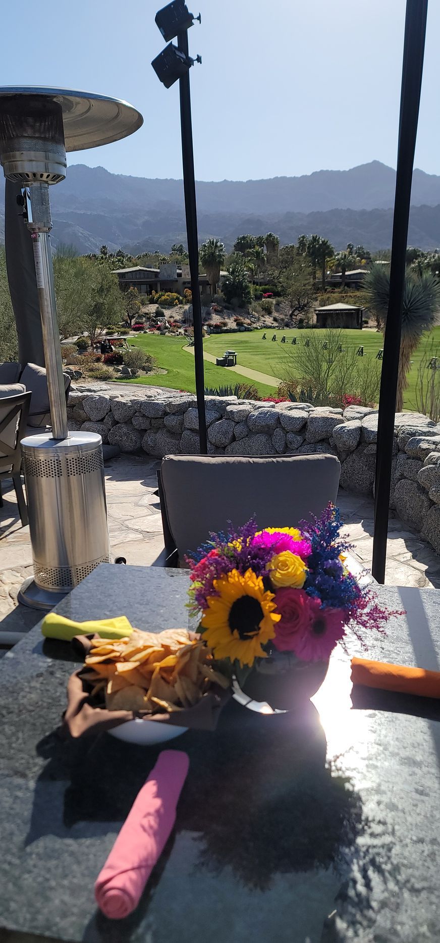 A table with a vase of flowers and a napkin on it