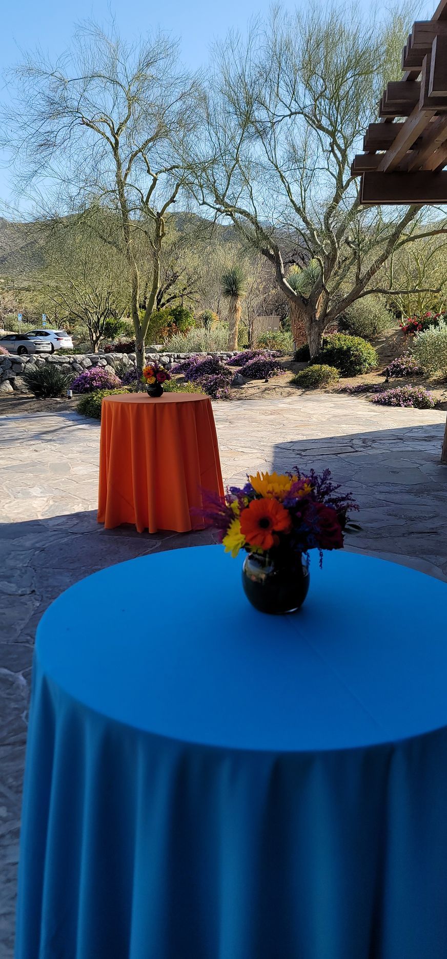 A table with a blue tablecloth and a vase of flowers on it.