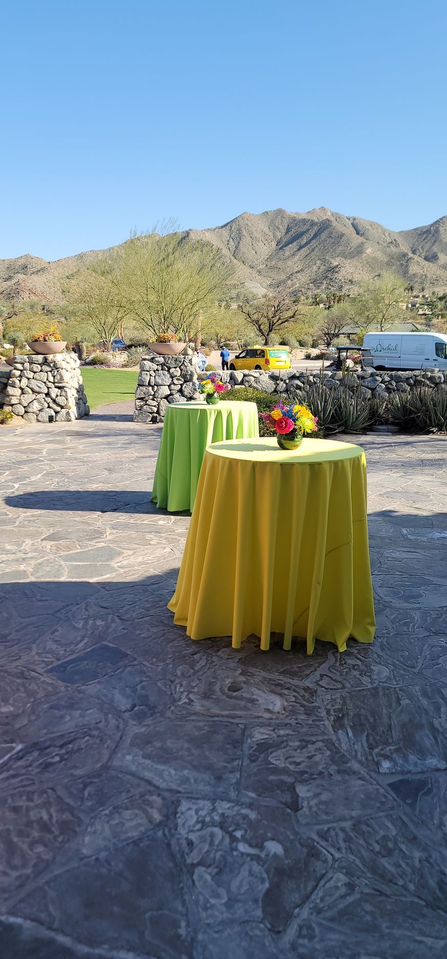 A patio with tables and a mountain in the background.
