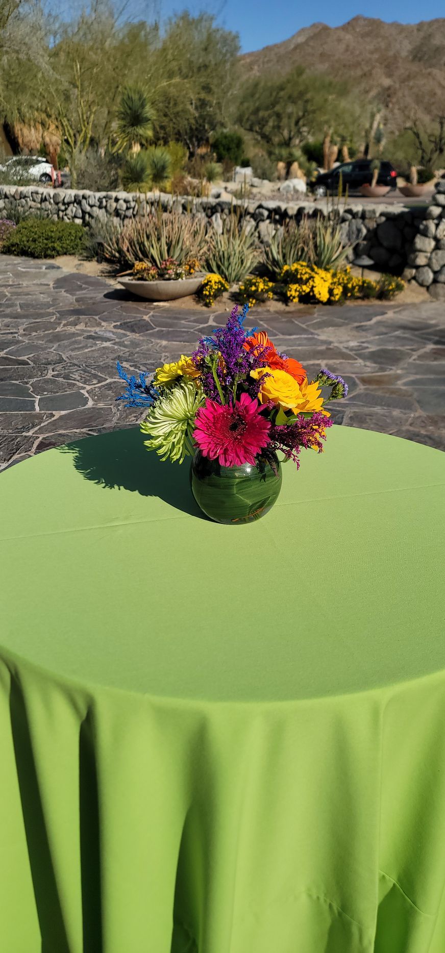 A vase of flowers is sitting on a table with a green tablecloth.