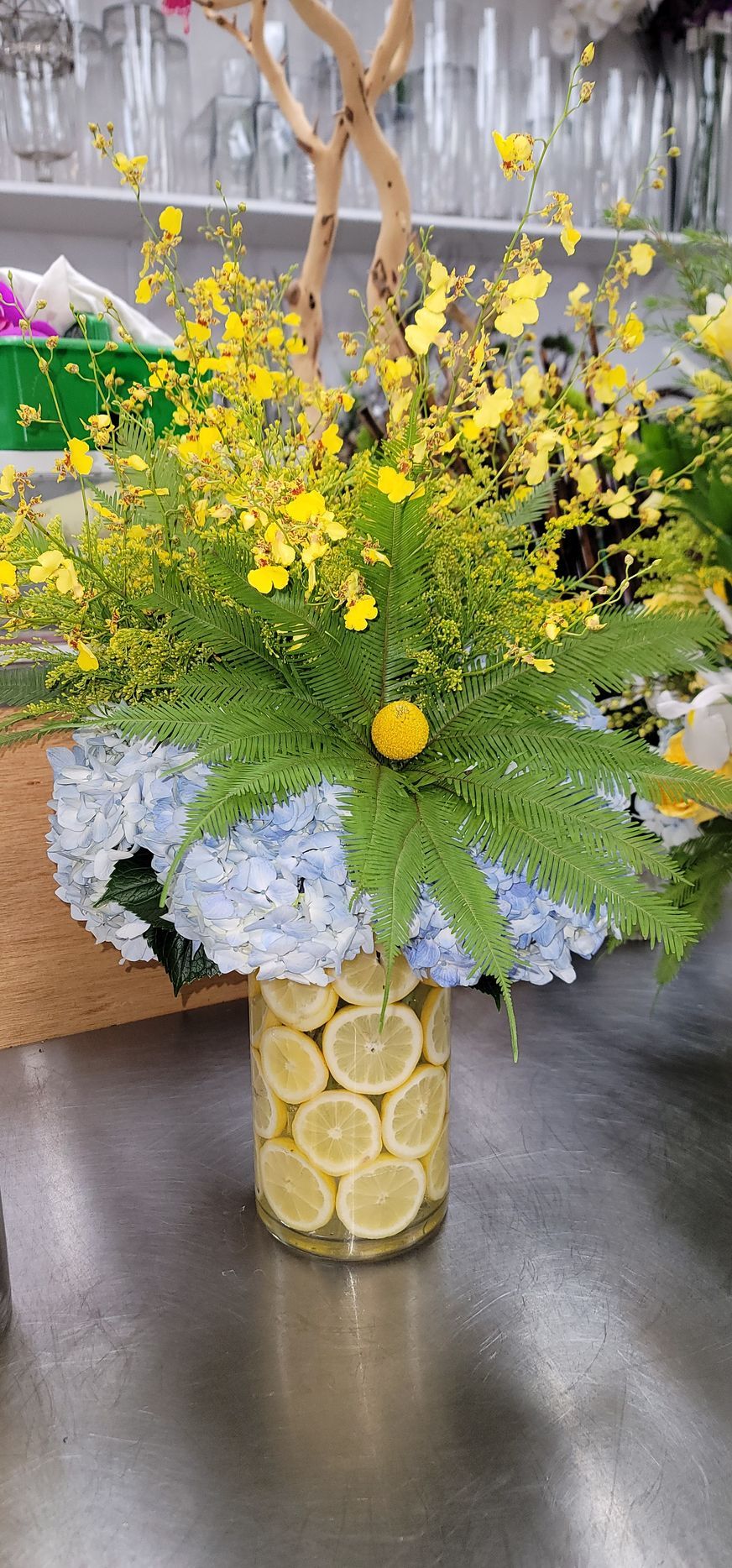 A vase filled with lemon slices and flowers on a counter.