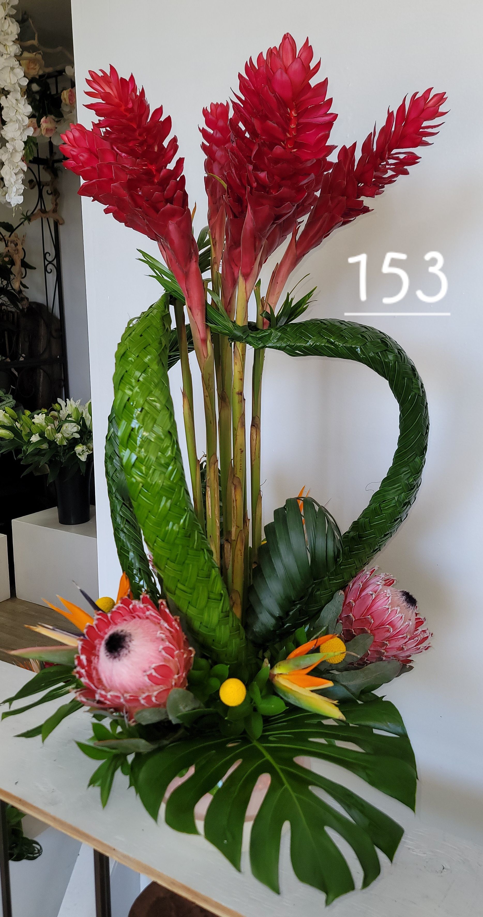 A bouquet of flowers in a vase with the number 153 on it