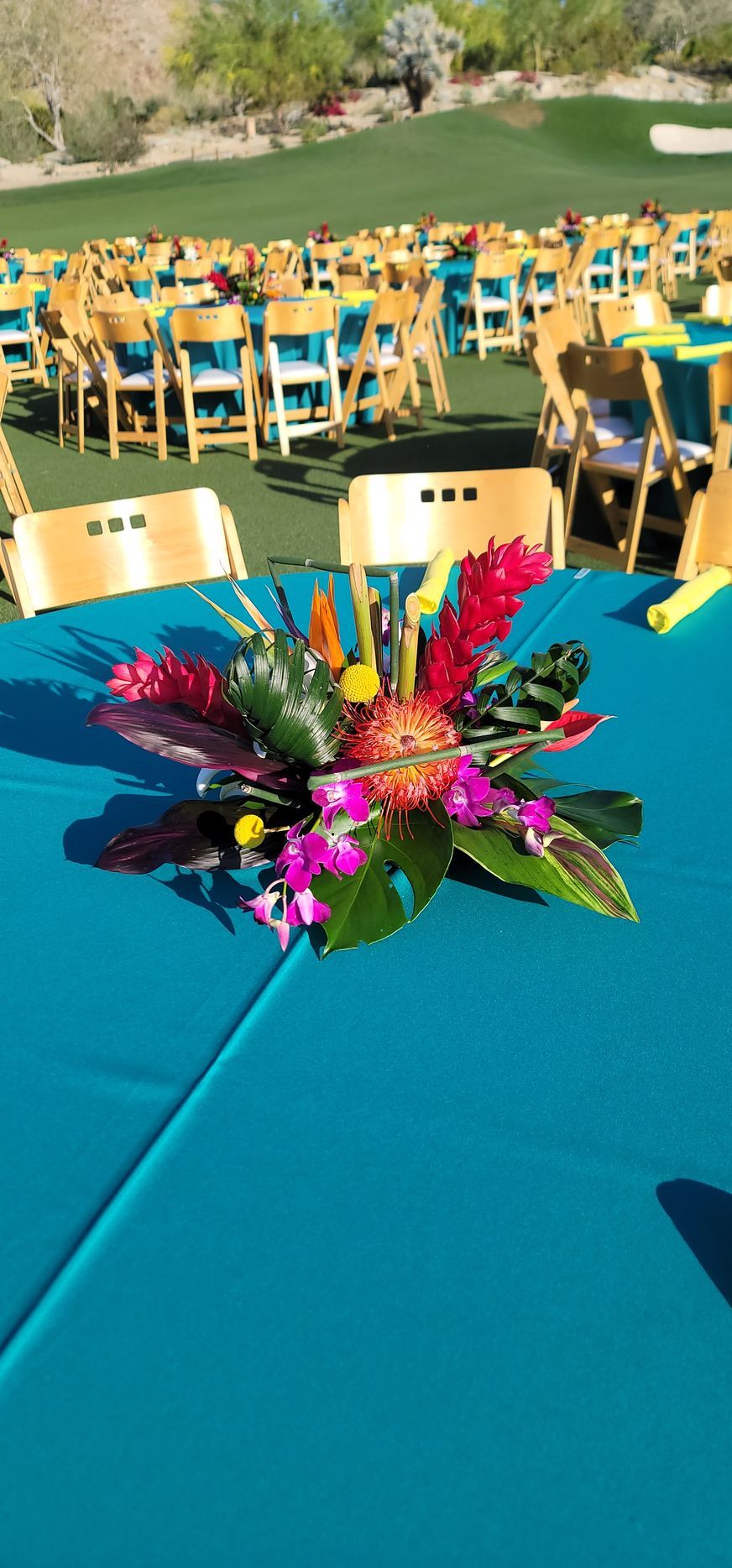 A table with a blue tablecloth and flowers on it.