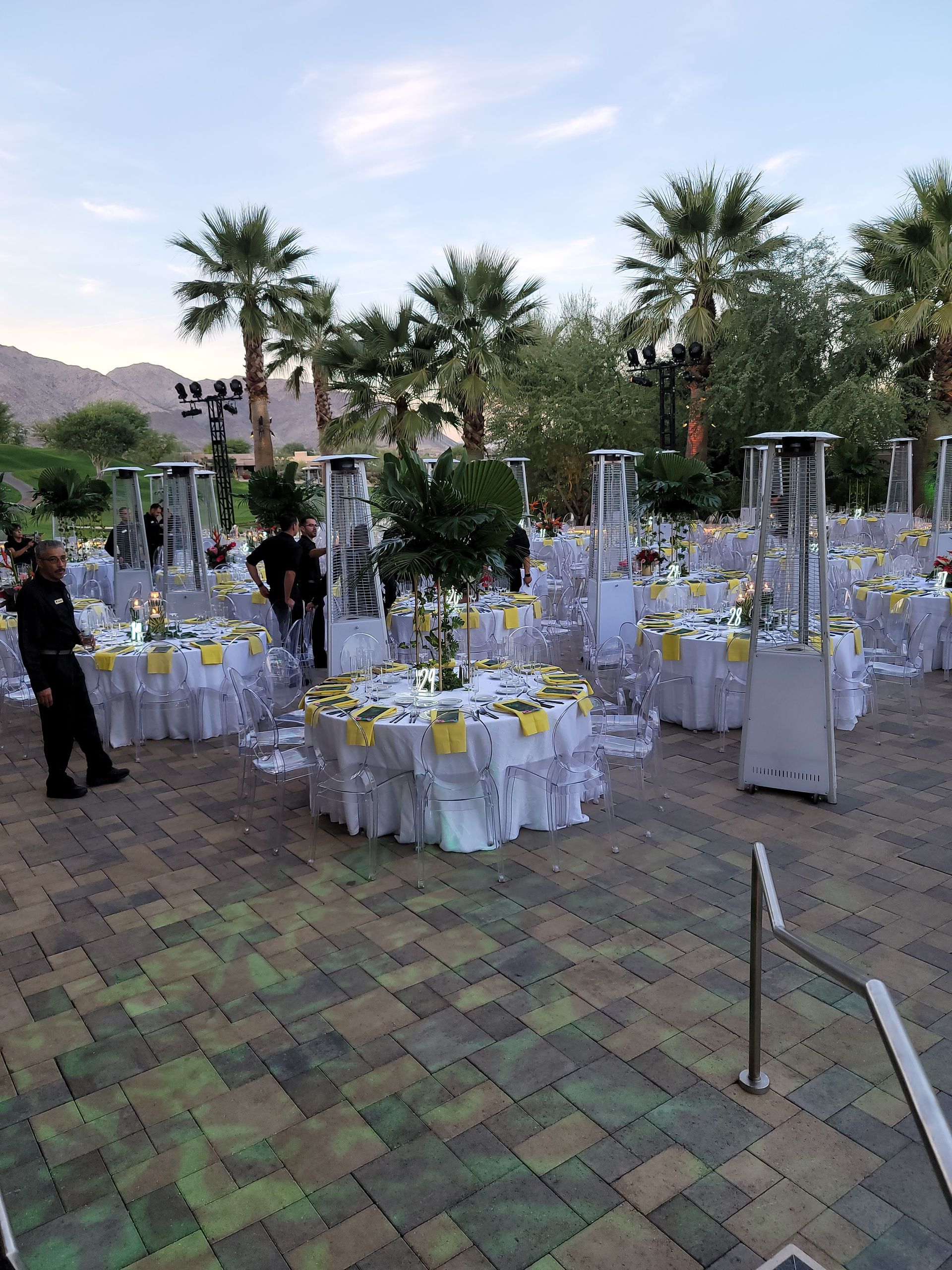 A large patio with tables and chairs set up for a wedding reception.