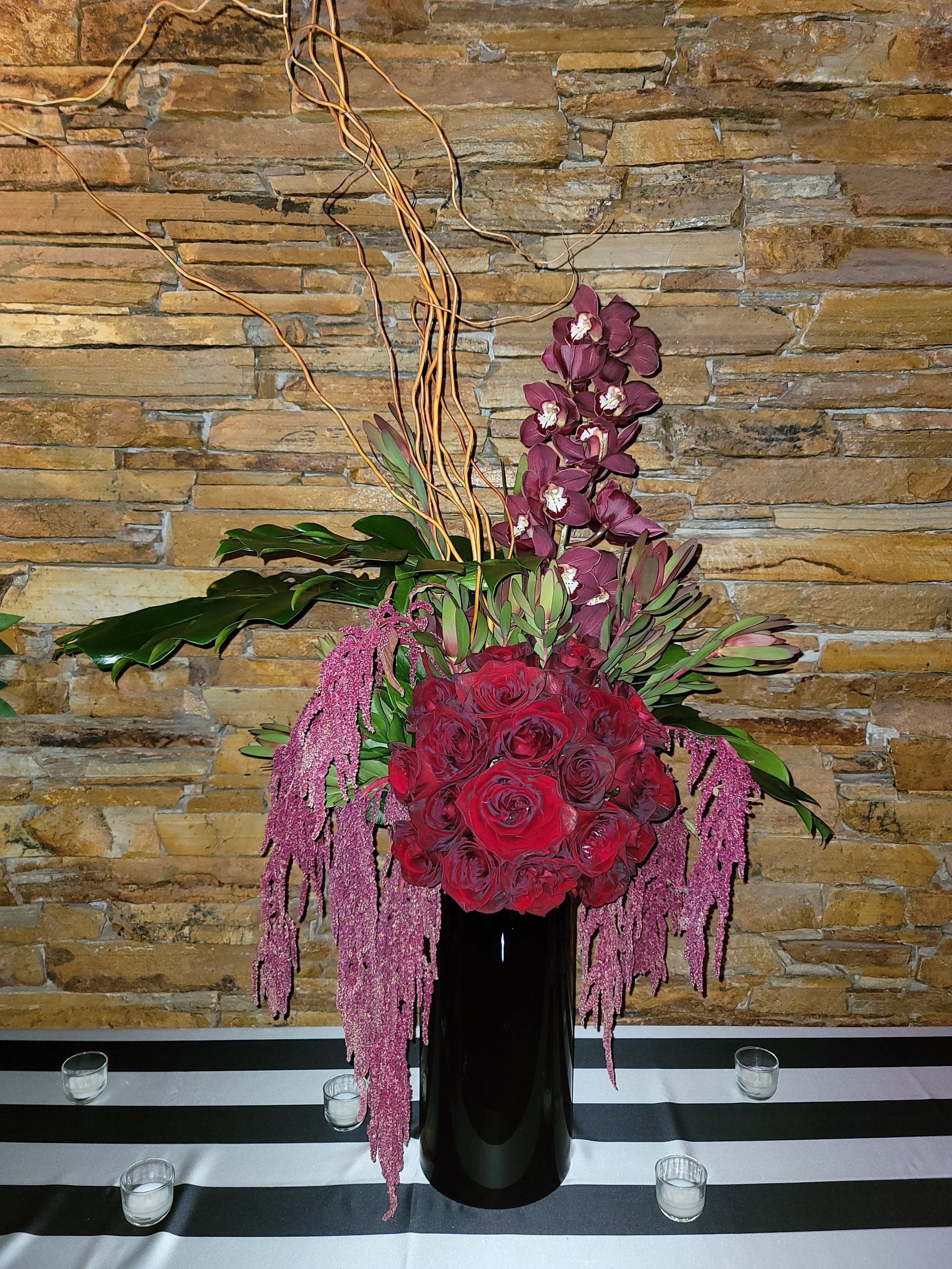 A vase filled with red and purple flowers is sitting on a table.