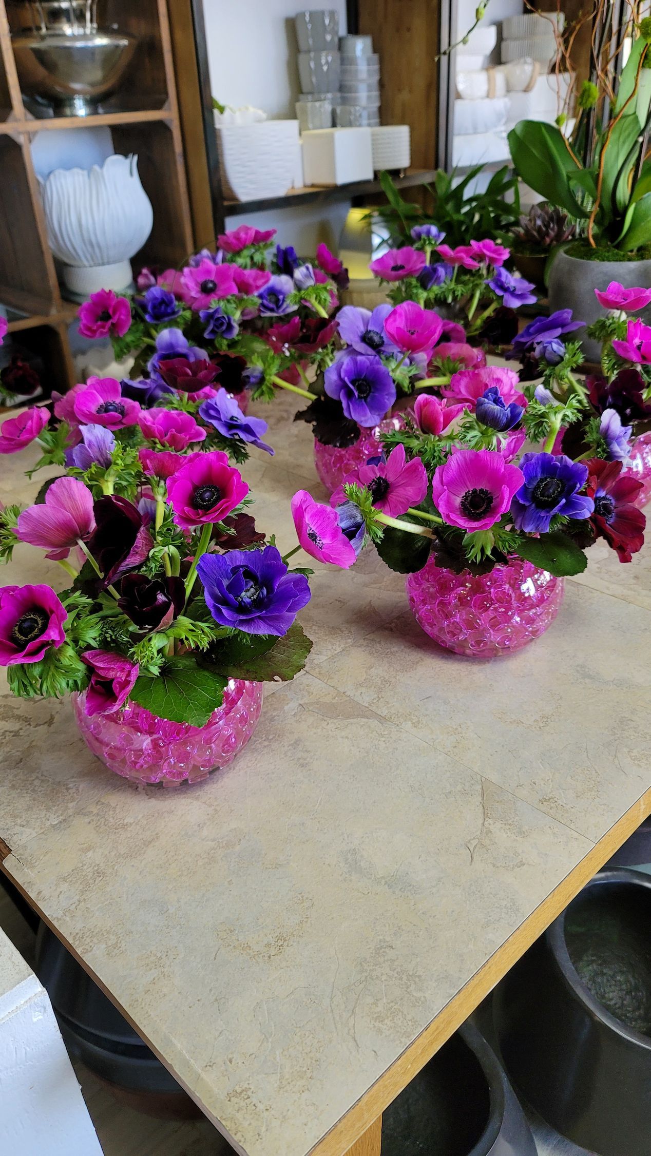 A table topped with vases filled with pink and purple flowers.