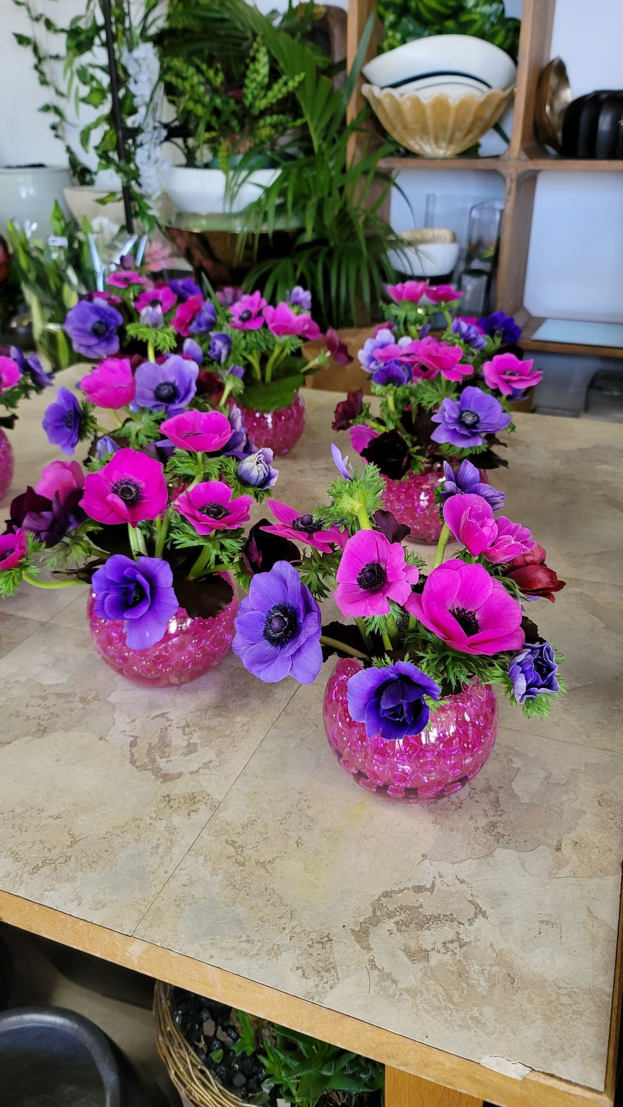 A table topped with vases filled with pink and purple flowers.