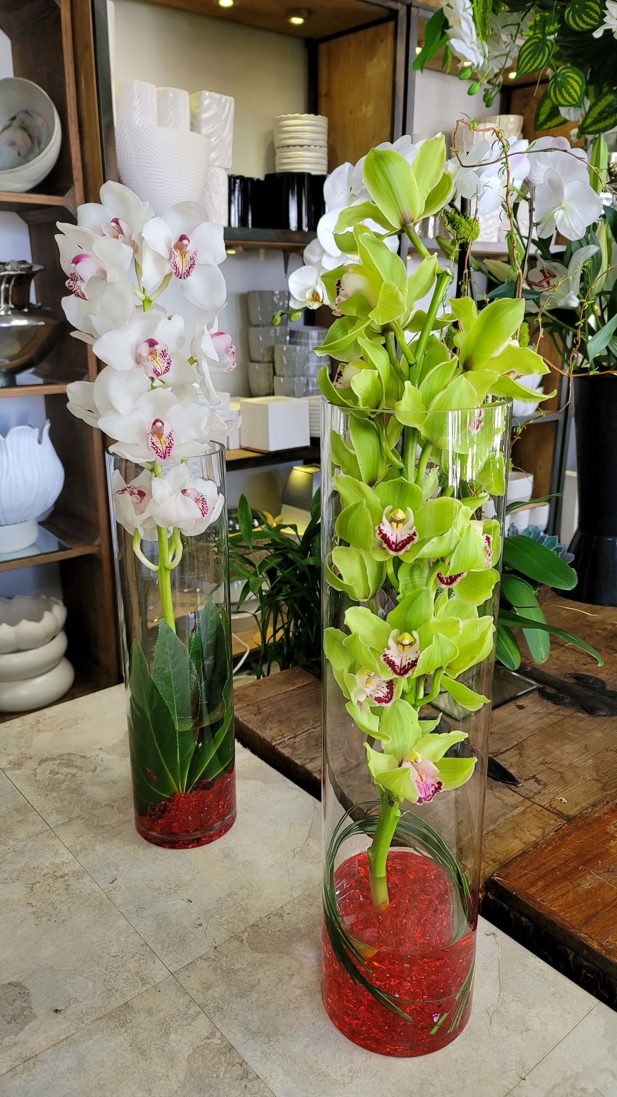 Two vases filled with flowers are sitting on a table.