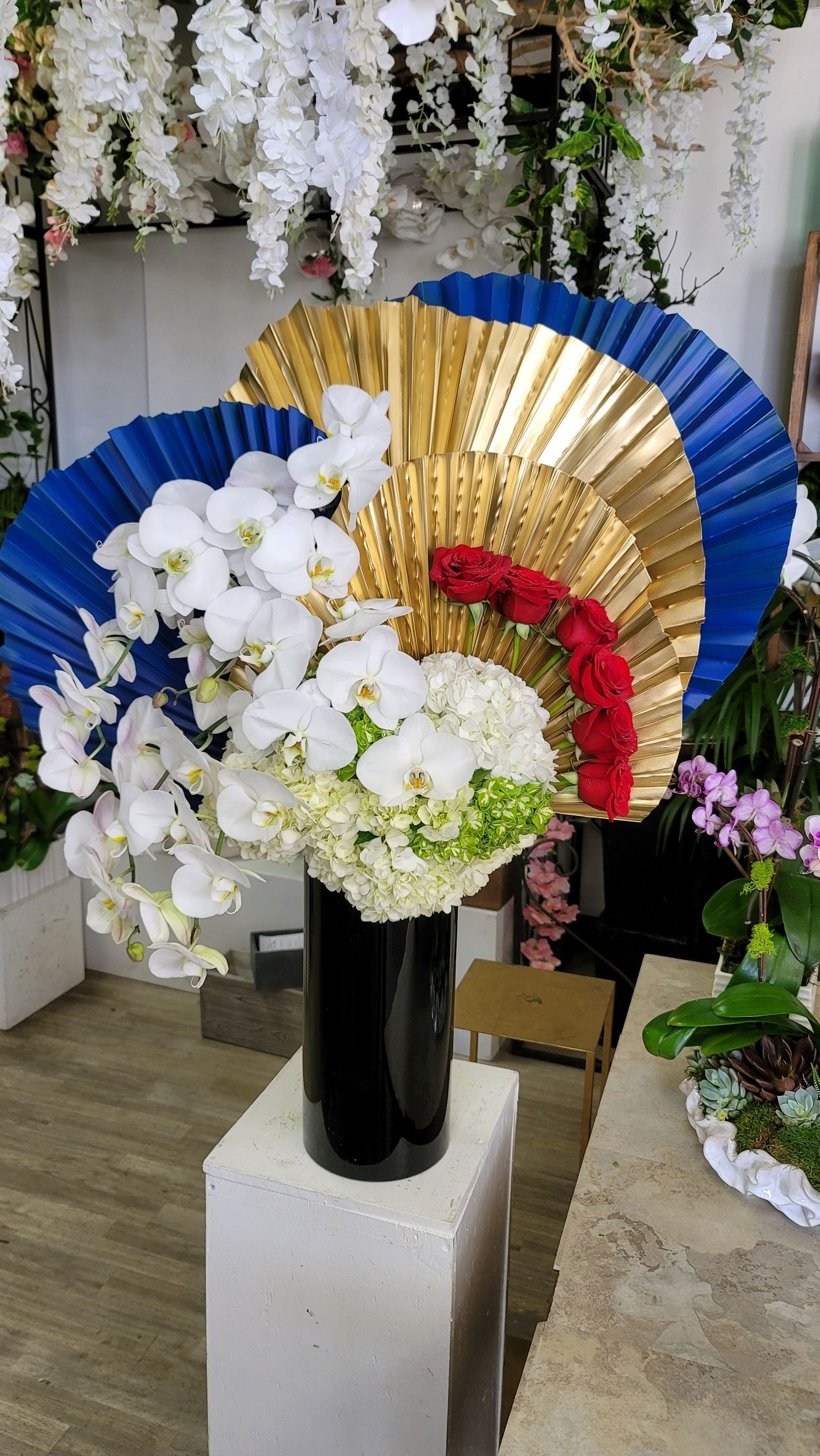 A vase filled with flowers and fans in a room.