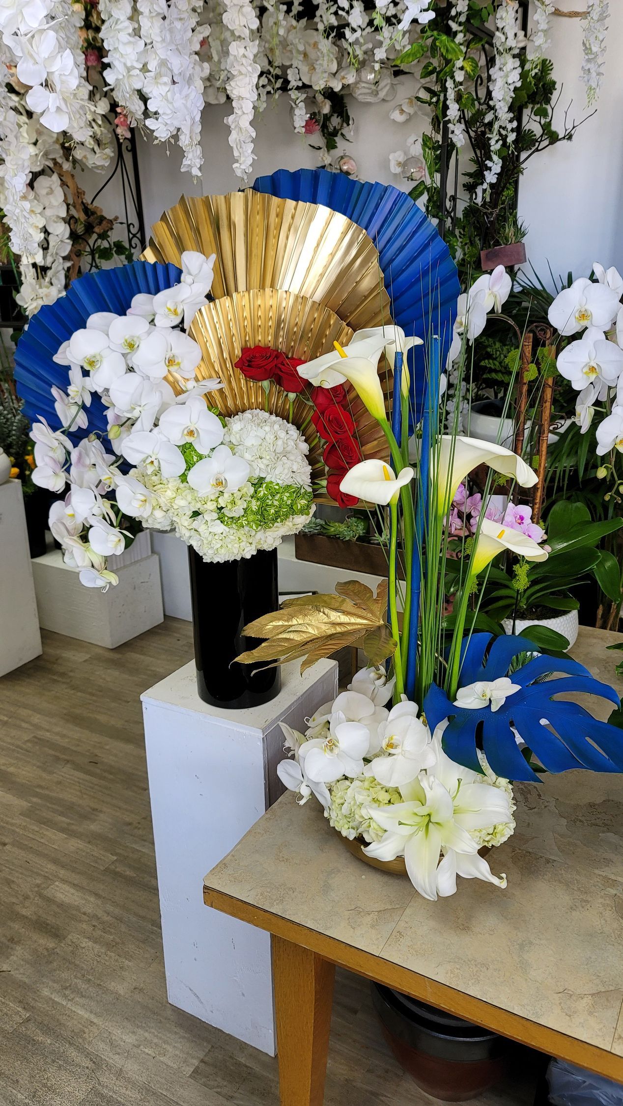 A table with a vase of flowers and a fan on it.
