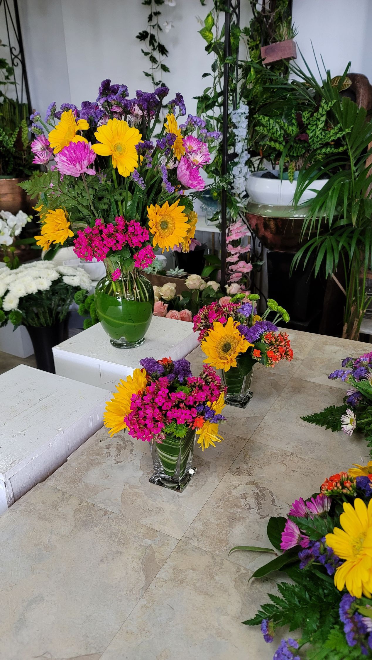 A bunch of vases filled with flowers are sitting on a table.
