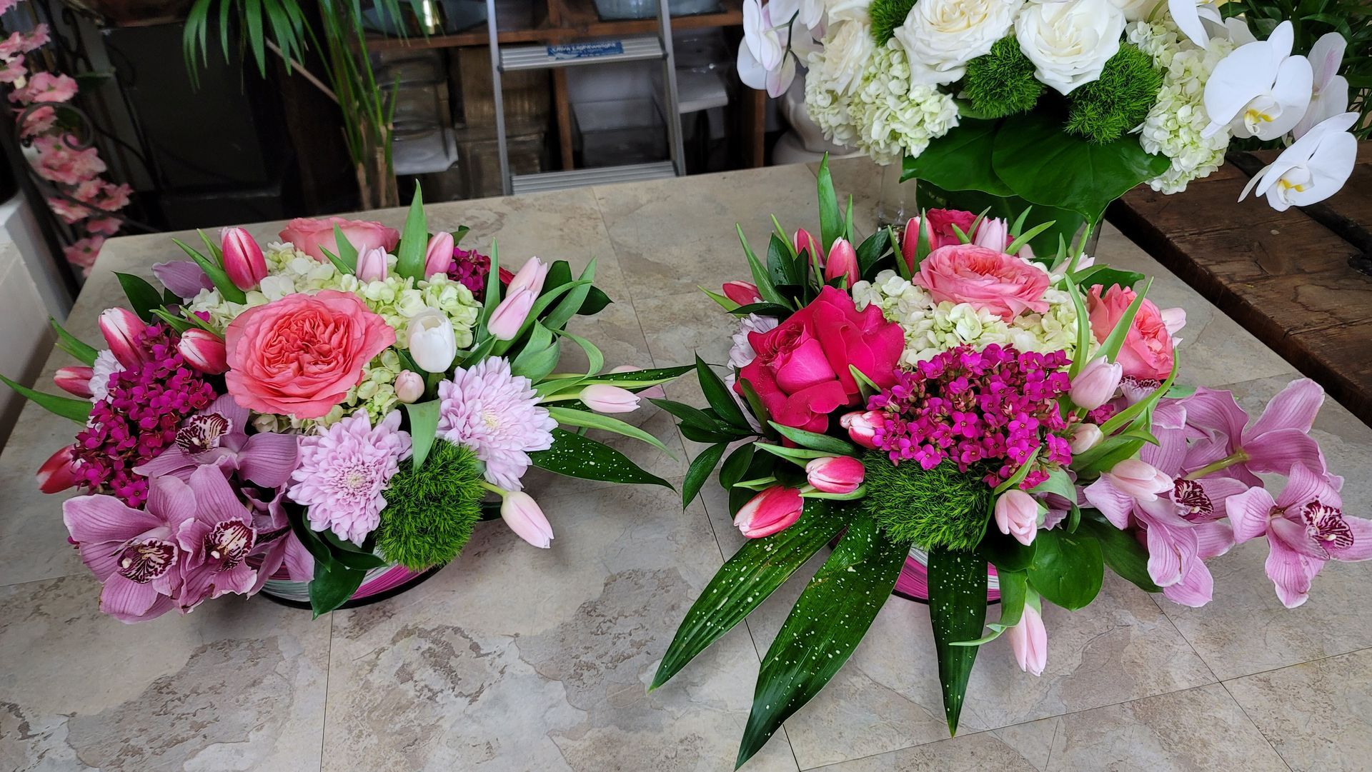 Two vases filled with pink and white flowers are sitting on a table.