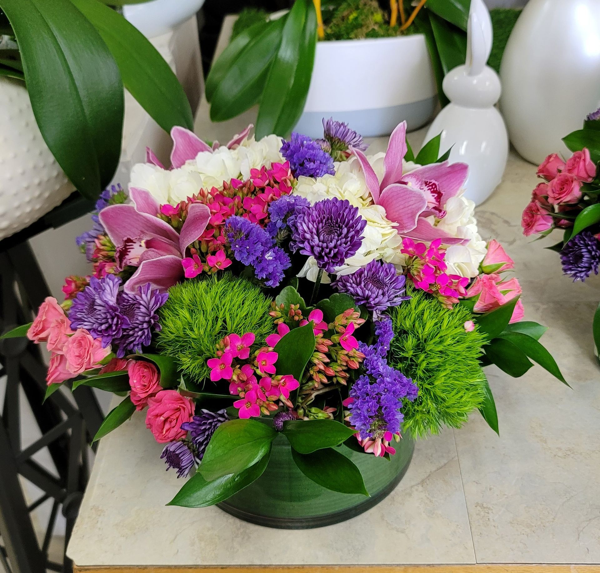 A vase filled with pink and purple flowers sits on a table