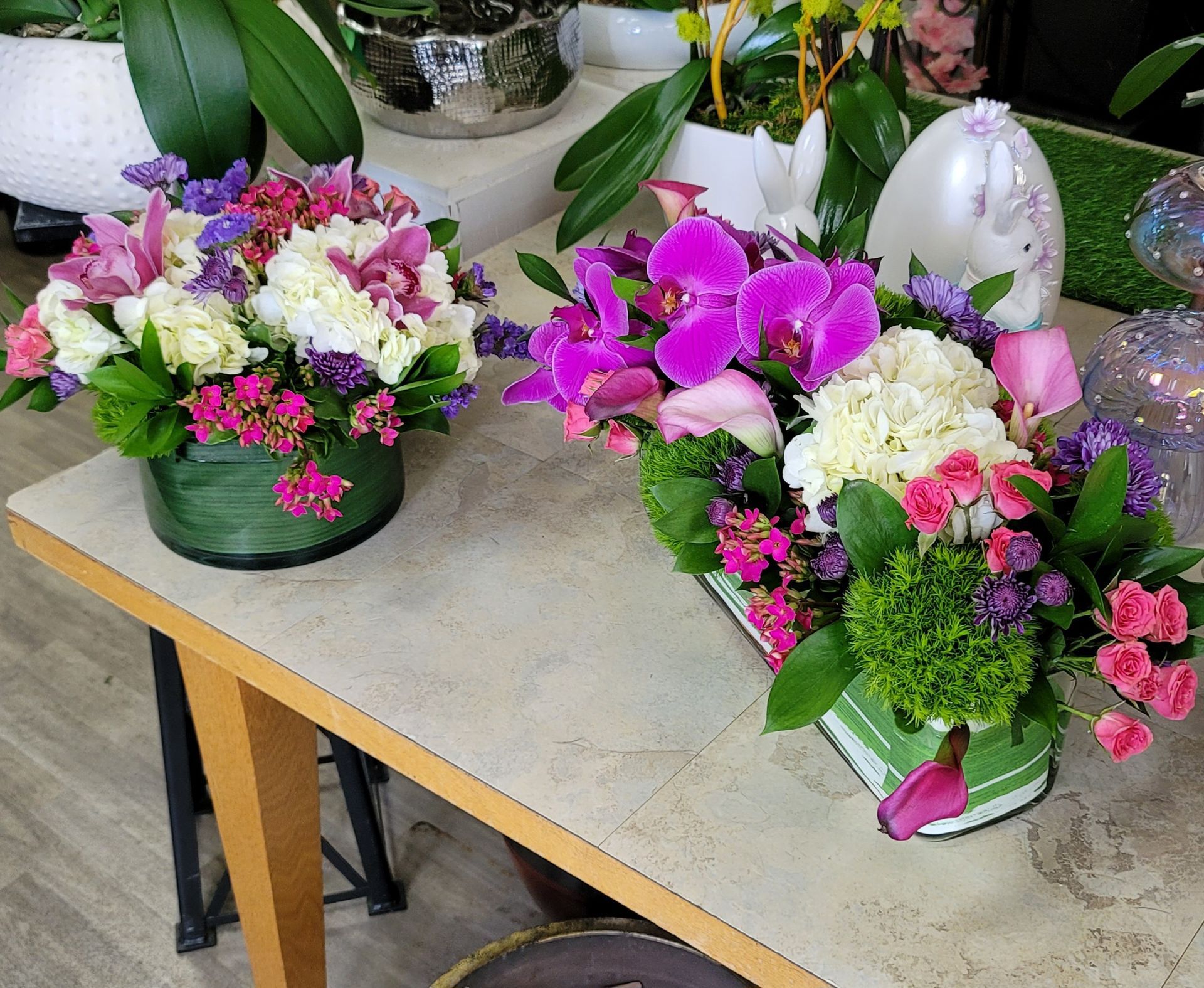Two vases of flowers are sitting on a table.