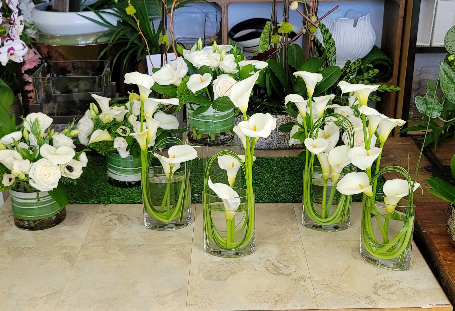 A bunch of vases filled with white flowers on a table