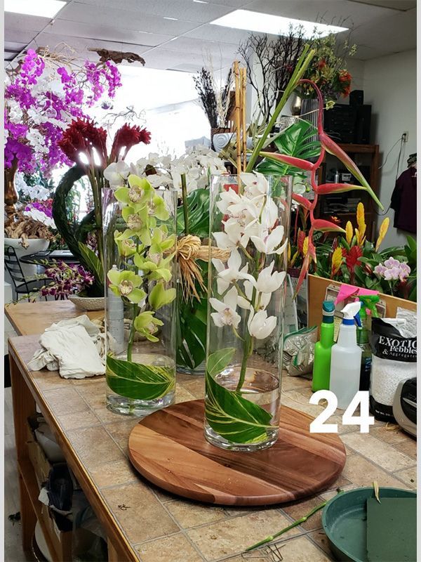 A bunch of vases filled with flowers are sitting on a wooden table.