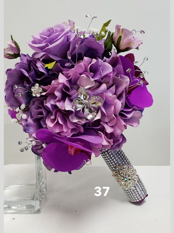A bouquet of purple flowers with rhinestones on the handle