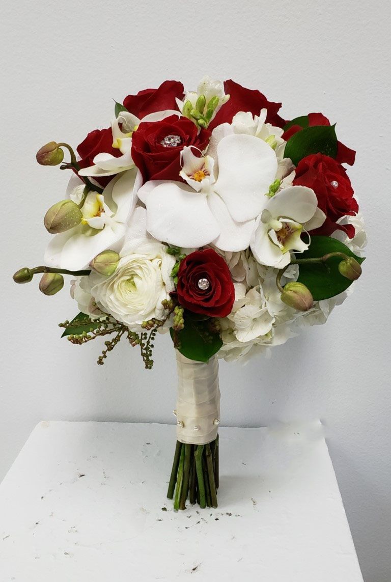 A bouquet of red and white flowers is sitting on a table.