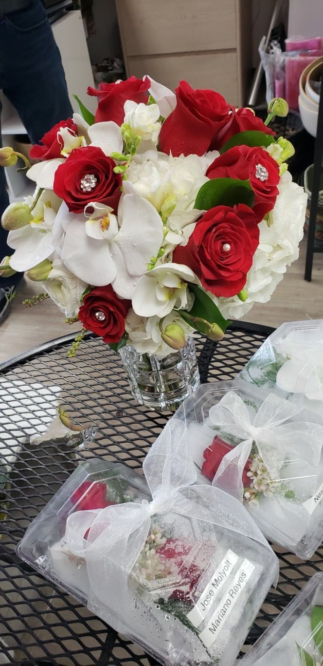 A bouquet of red and white flowers in a vase on a table.