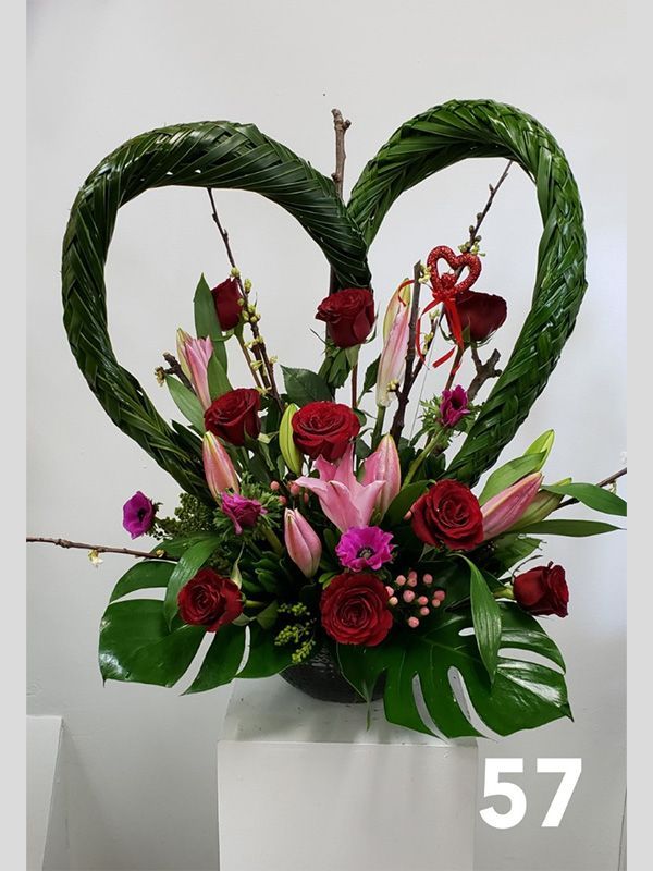 A heart shaped arrangement of flowers with the number 57 below it