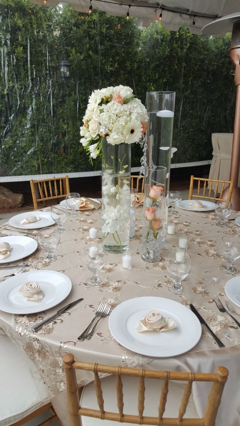 A table with plates , utensils , and a vase of flowers on it.