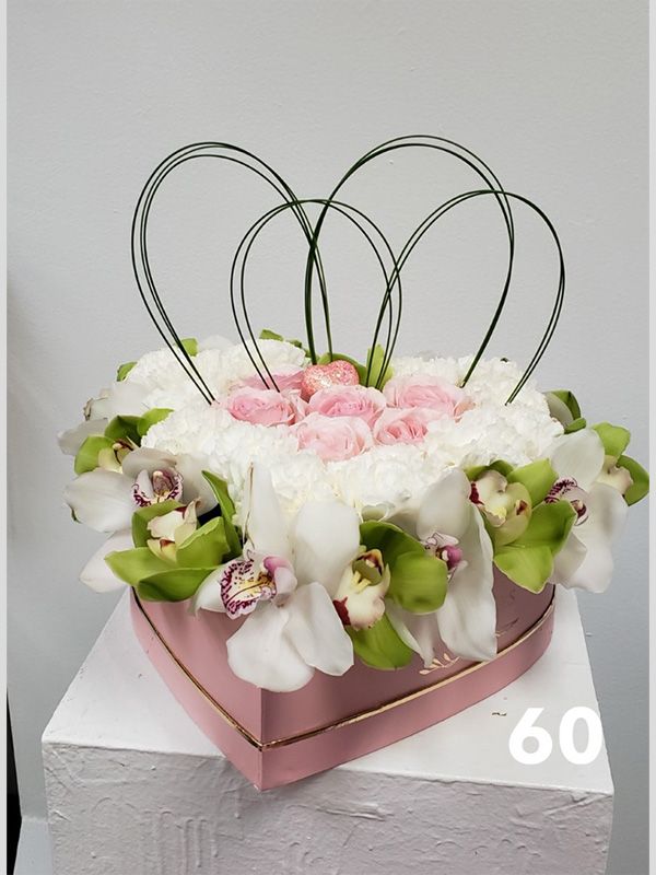 A heart shaped box filled with flowers and the number 60