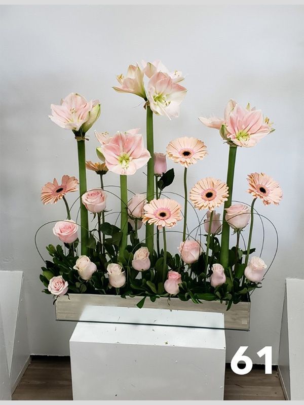 A vase filled with pink flowers and the number 61 on the bottom
