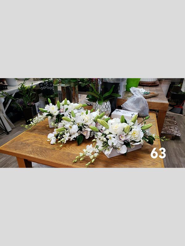 A wooden table topped with a bunch of white flowers.
