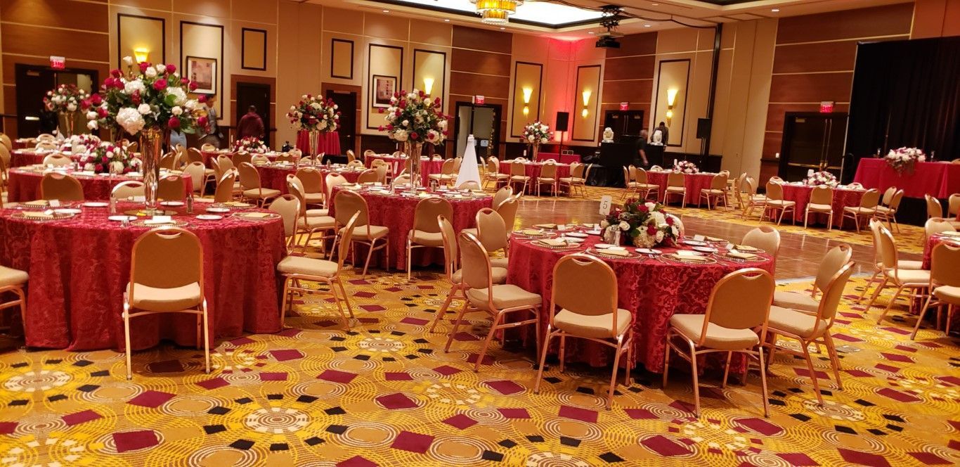 A large room with tables and chairs set up for a wedding reception.
