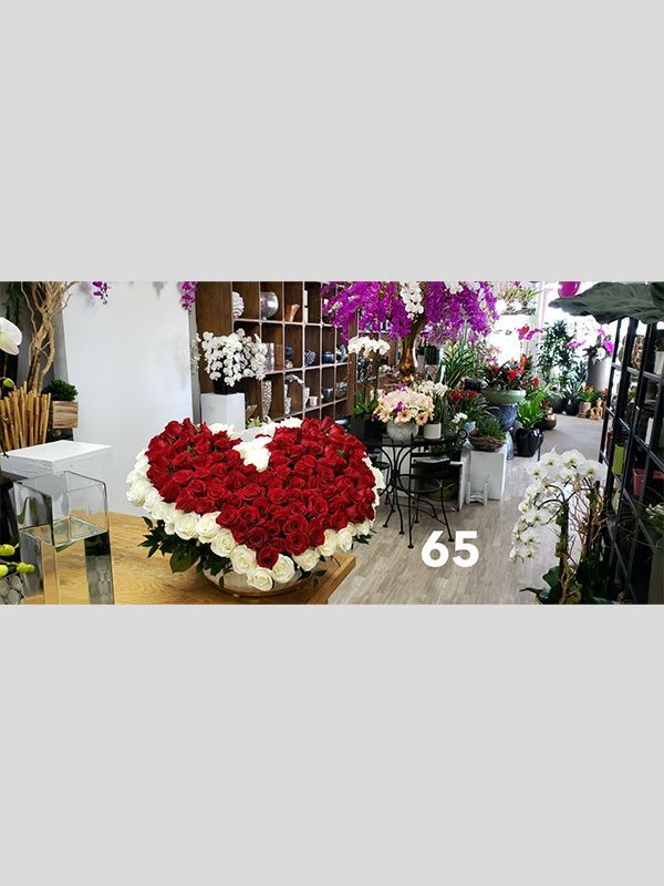 A large heart shaped bouquet of red and white roses in a flower shop.