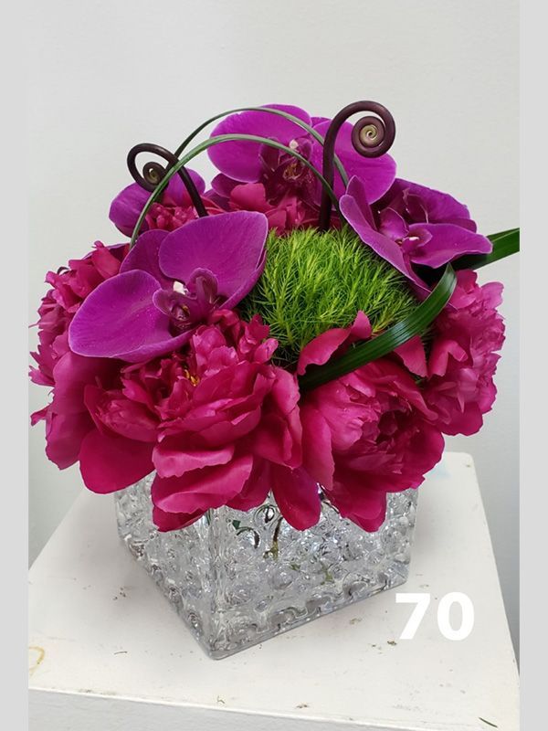 A vase filled with purple flowers and the number 70 on the bottom