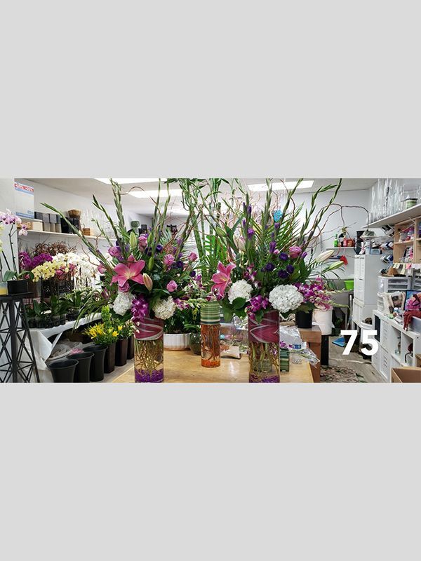 A bunch of vases filled with flowers are sitting on a table.