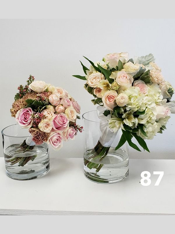 Two vases filled with flowers are sitting on a table.