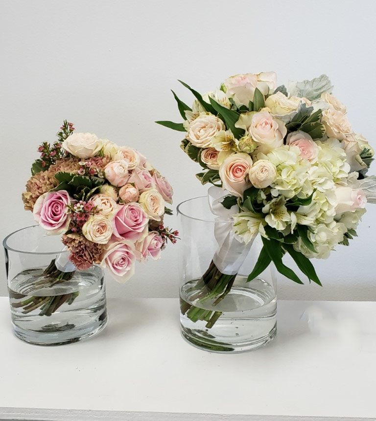 Two vases filled with flowers are sitting on a table.