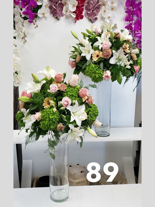Two vases filled with flowers and the number 89 on the bottom