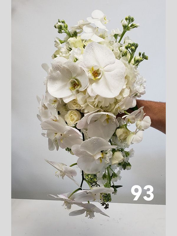 A person is holding a bouquet of white flowers with the number 93 on it.
