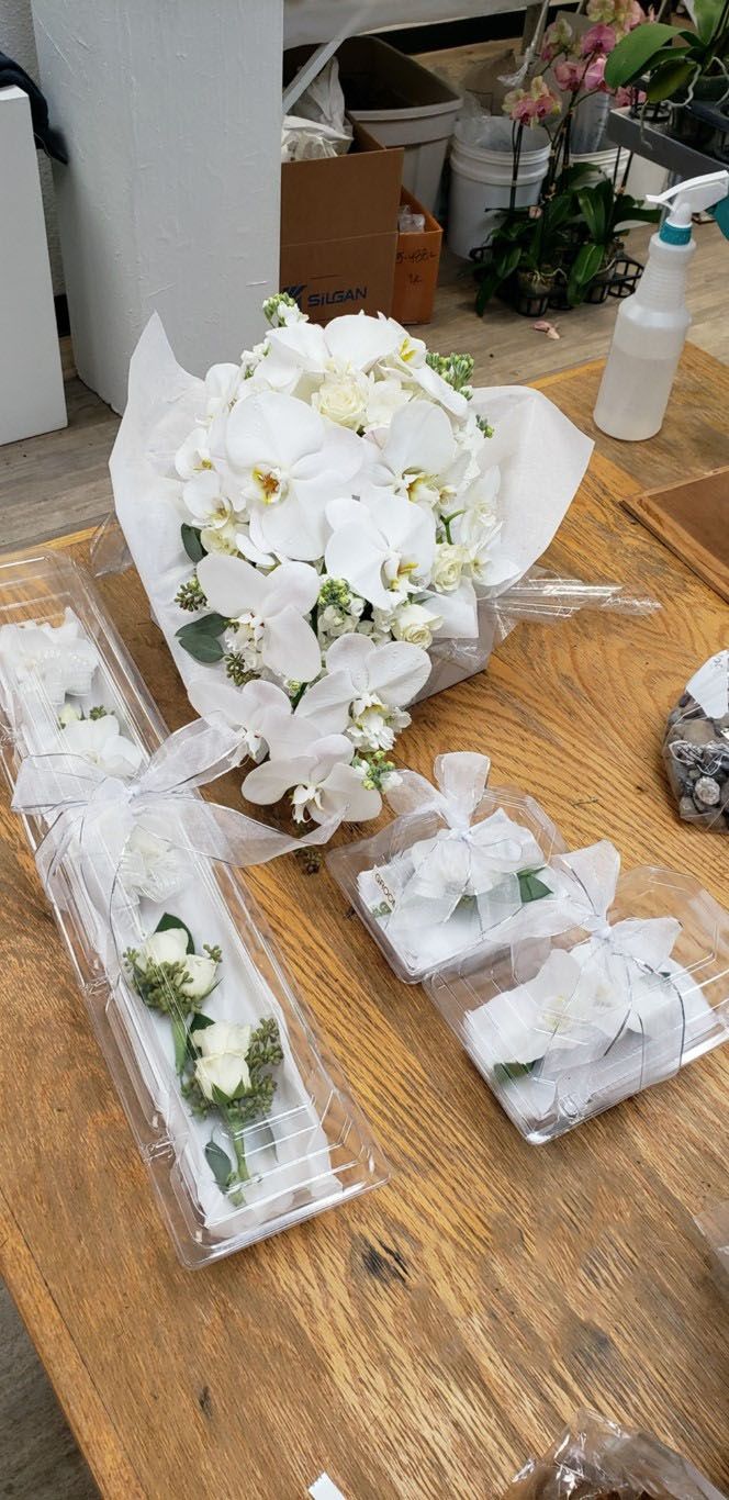 A bouquet of white flowers is sitting on top of a wooden table.