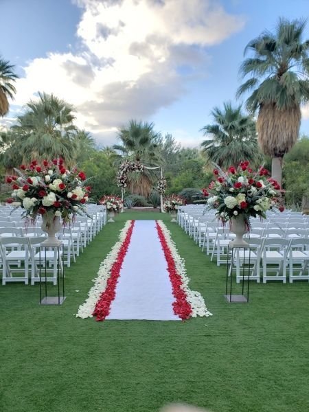 A wedding ceremony is taking place on a lush green field.