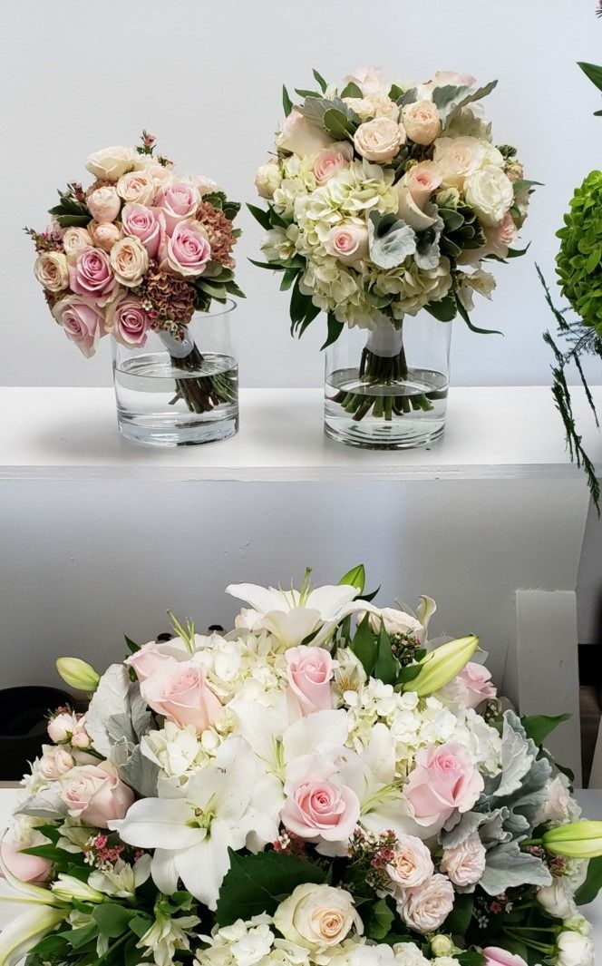Three vases filled with pink and white flowers are sitting on a table.