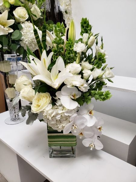 A vase filled with white flowers is on a table