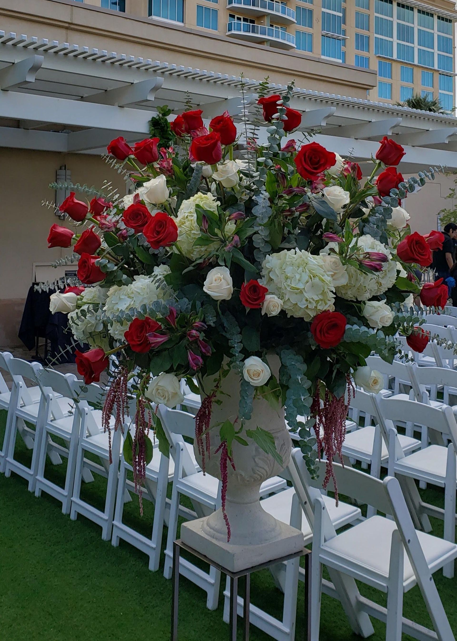 A large vase filled with red and white flowers is sitting on a table.