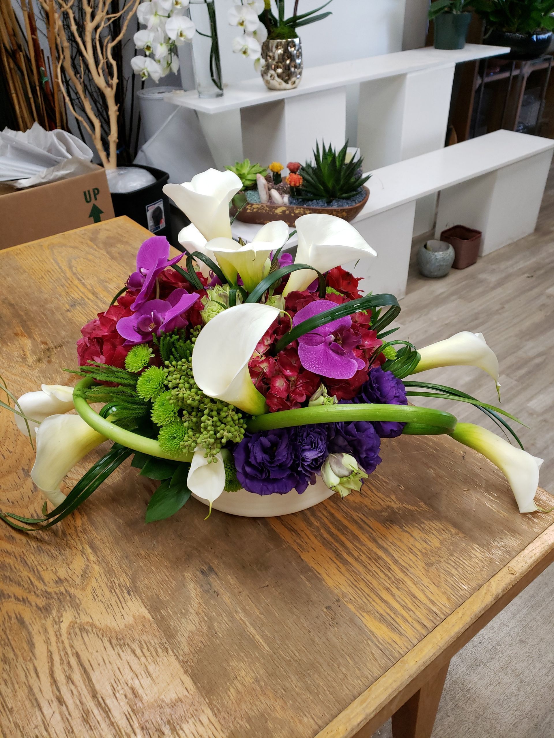 A bouquet of flowers is sitting on a wooden table.