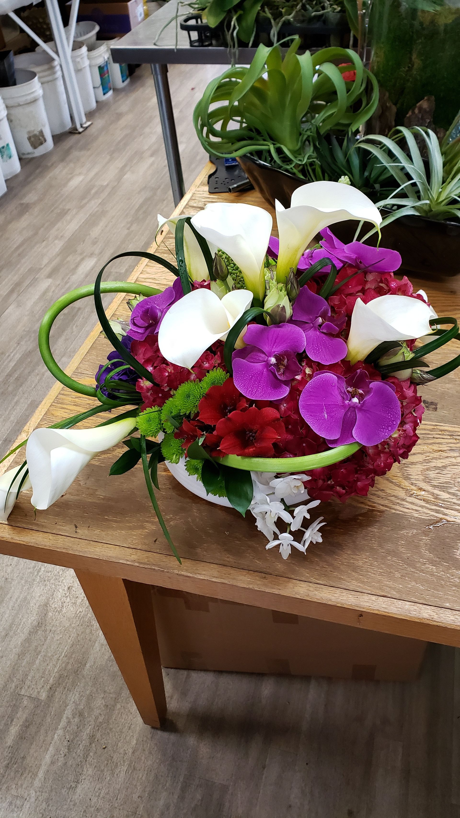 A bouquet of flowers is sitting on a wooden table.