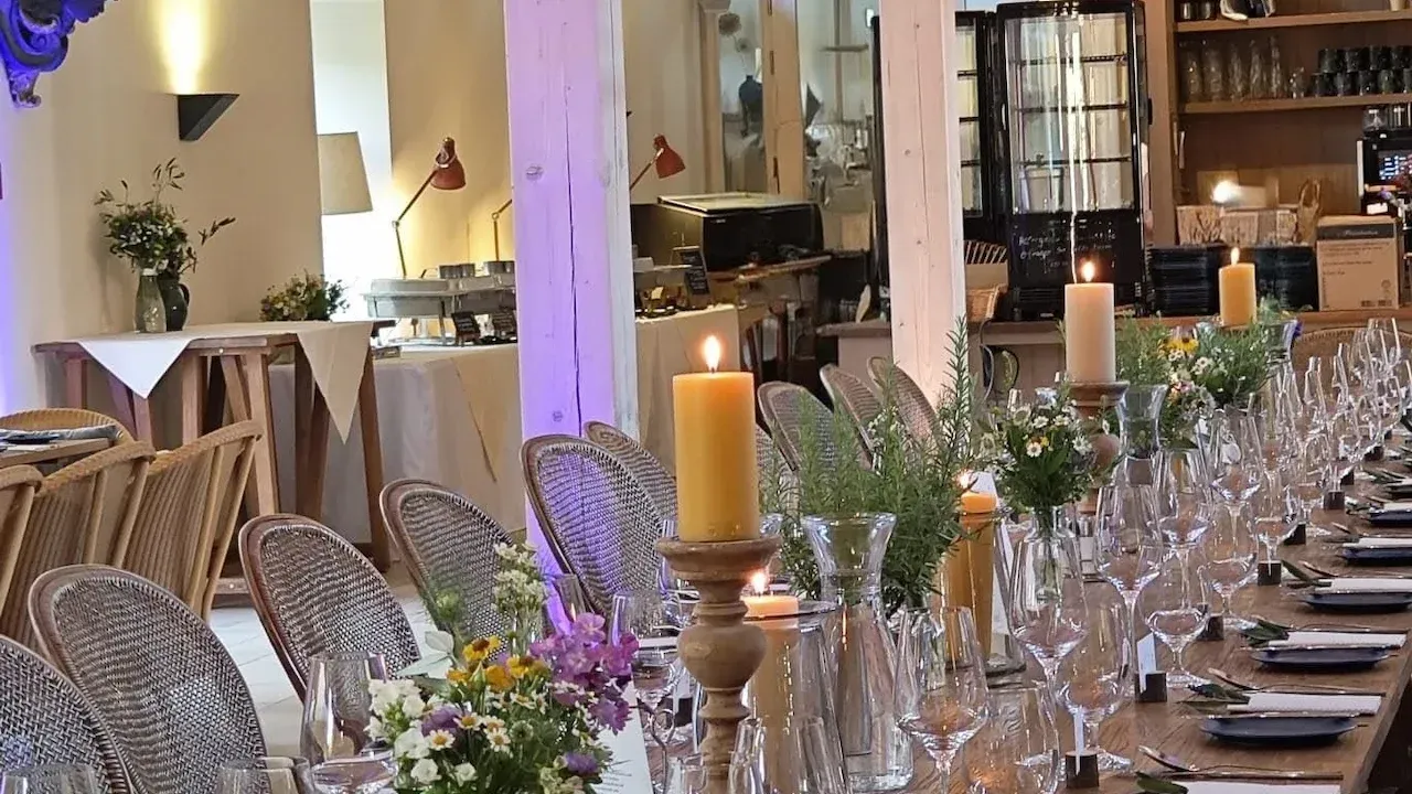 Gut Schmerwitz · großzügiger Innenbereich mit langer Holztafel, Kerzenlicht und natürlicher Hochzeitsatmosphäre in Brandenburg