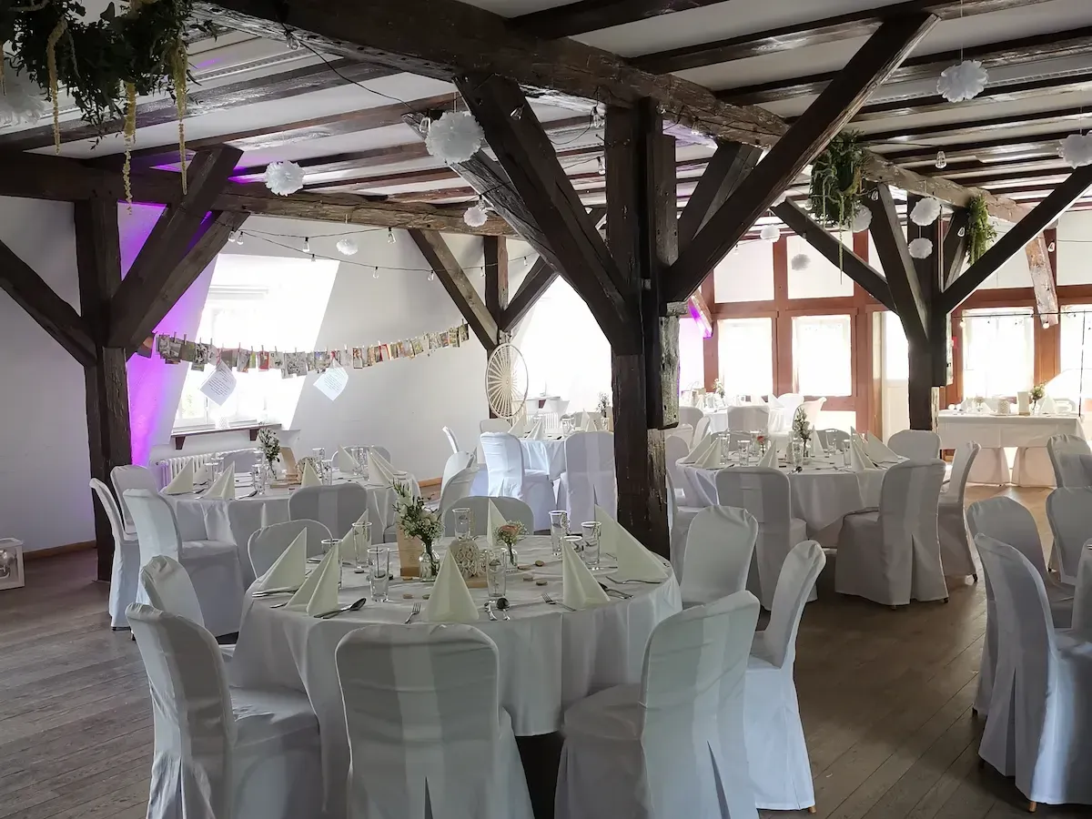 Hochzeitslocation Springbachmühle in Bad Belzig · liebevoll gedeckter Innenraum mit Fachwerk, Tischdekoration und stimmungsvollem Ambientelicht