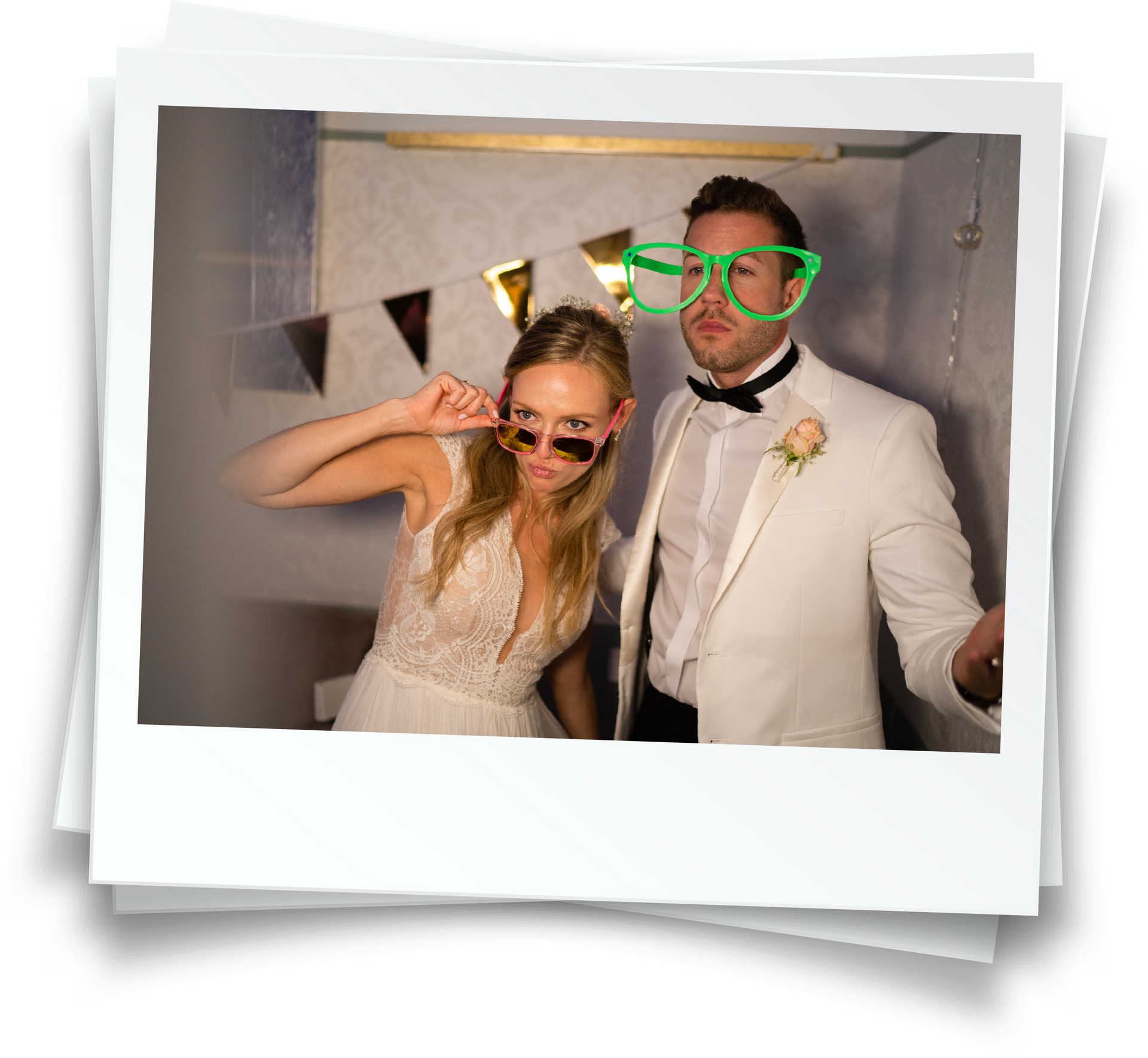 A bride and groom are posing for a picture in a photo booth.